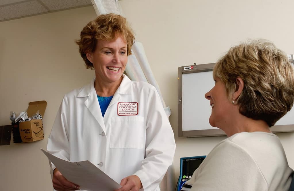Aesthetic provider in white coat consulting with a patient about lip filler treatment options